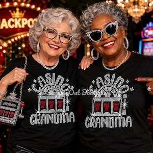 May include: Two black t-shirts featuring a rhinestone graphic of a slot machine with the number 777 and the text CASINO GRANDMA. One shirt is paired with a matching slot machine shaped handbag with a red lever and a 777 display.