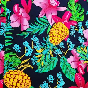 Puede incluir: Un fondo negro con un estampado tropical con orquídeas rosas, hojas verdes y piñas amarillas.