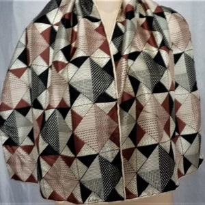 Peut inclure: Un foulard en soie à motifs géométriques de couleur marron, noir et crème. Le foulard a une bordure crème.