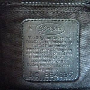 May include: A black leather tag with the text "Brigiton" and the words "The Brighton Collection handbags are individually crafted from quality leathers. Any markings on the surface are part of the natural beauty, texture and character of the leather, which make each bag unique" and the number "N&deg; 864885".