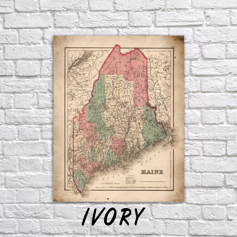 Pu&ograve; includere: Una mappa antica del Maine, con cartografia dettagliata in rosso, verde e beige. La mappa &egrave; incorniciata e montata su un muro di mattoni bianchi. La parola "IVORY" &egrave; stampata in nero in basso.