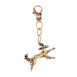 May include: A gold-colored metal keychain featuring a detailed sculpture of a dog jumping in mid-air. The keychain has a metal clasp and a chain.
