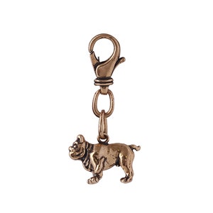Op de afbeelding: Een bronzen bulldog sleutelhanger met een metalen sluiting. De bulldog staat op alle vier poten met zijn hoofd gedraaid naar de zijkant.