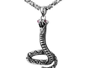 May include: Silver snake pendant necklace with a detailed design and red gemstone eyes. The chain is a silver box chain.