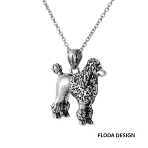 Op de afbeelding: Een zilveren ketting met een gedetailleerde zilveren poedelhanger. De poedel staat met zijn hoofd naar de zijkant gedraaid en zijn staart opgerold.