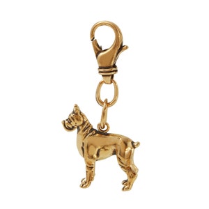 May include: A gold-colored metal keychain featuring a detailed boxer dog figurine. The keychain has a spring-loaded clasp for attaching to keys or bags.
