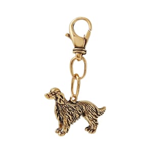 May include: Gold-toned metal keychain featuring a detailed, three-dimensional sculpture of a golden retriever dog.