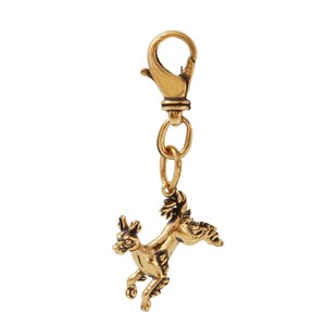 May include: A gold-toned metal keychain featuring a detailed, stylized depiction of a dog in a jumping pose. The keychain has a lobster clasp for attaching to a bag or keys.