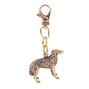 May include: Gold-colored metal keychain featuring a detailed sculpture of a dog. The keychain has a metal loop and a spring clasp.