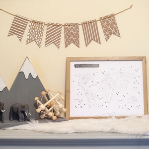 Könnte beinhalten: Ein gerahmter Schwarzweiß-Druck einer Weltkarte mit dem Text "What a Wonderful World" oben. Die Karte besteht aus geometrischen Formen und hat kleine schwarze Dreiecke, die über die Oberfläche verteilt sind. Der Druck hängt an einer Wand mit einem braunen Papierbanner mit weißen geometrischen Mustern darüber.