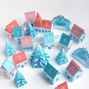 May include: A printable advent calendar featuring a tiny village with houses and trees. The houses are pink, blue, and white with numbers 1 through 24 on them. The trees are blue and green with white snow on the tops. The text "My Tiny Village Advent Gift Box Calendar" is at the top of the image.