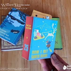 May include: A blue and red miniature book with the title "How I Met Santa Claus" and the number 25 on the cover. The book is part of a wizard bookcase advent calendar.