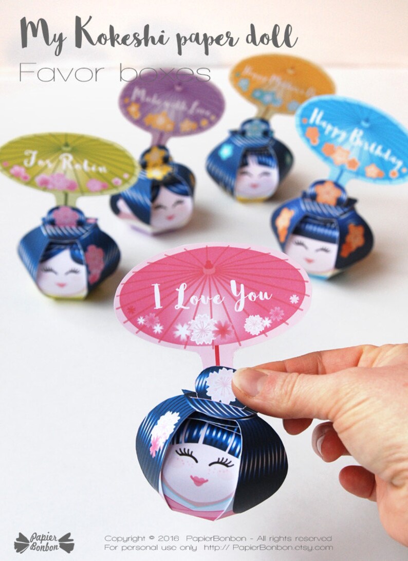 May include: A set of colorful Kokeshi paper doll favor boxes with different messages on the umbrellas. The messages include "I Love You", "Happy Birthday", "For Robin", and "Make a Wish".