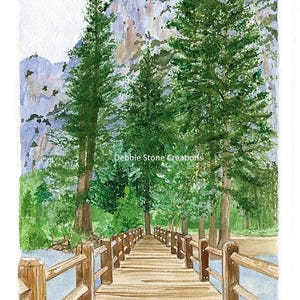 Op de afbeelding: Aquarel schilderij van een houten brug die naar een bos leidt. Hoge groene bomen staan langs de brug, met een berg op de achtergrond. Het schilderij is gesigneerd "D. Stone, 2017" en bevat de tekst "Debbie Stone Creations".