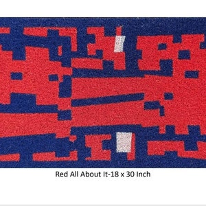 May include: A rectangular red and blue doormat with a geometric design. The mat is 30 inches long and 18 inches wide. The text "Red All About It-18 x 30 Inch" is printed on the mat.