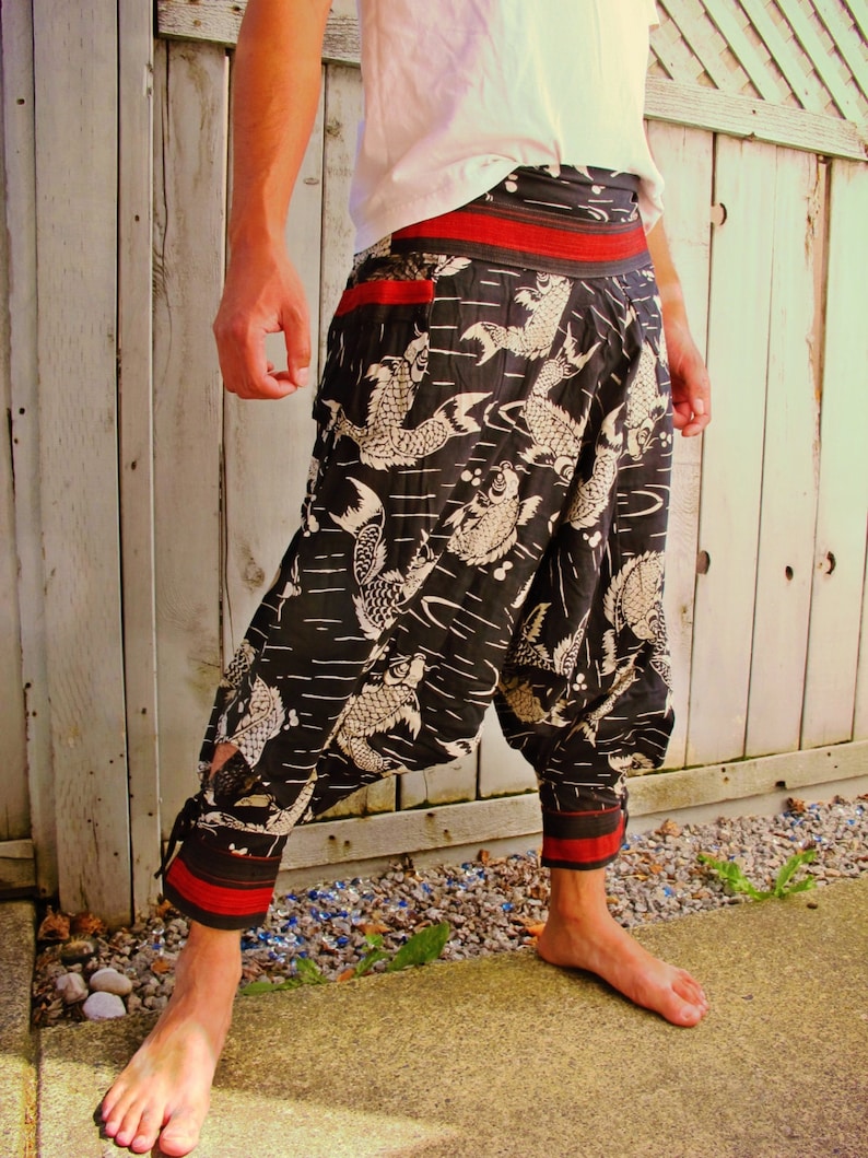 May include: Black and white patterned pants with a red waistband and trim. The pants feature a koi fish design and a loose, comfortable fit. The pants are made of a lightweight fabric, perfect for warm weather.