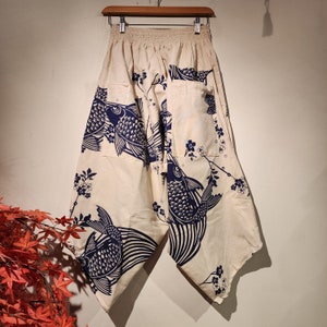 May include: White pants with a blue and white fish and floral print. The pants have a wide leg and a loose fit.