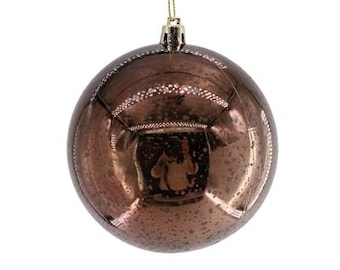 Könnte beinhalten: Eine kugelförmige Weihnachtskugel mit einer reflektierenden, metallisch bronzefarbenen Oberfläche und einer gealterten, gesprenkelten Textur. Die Kugel hat eine goldfarbene Kappe an der Oberseite mit einer dünnen goldenen Schnur zum Aufhängen.