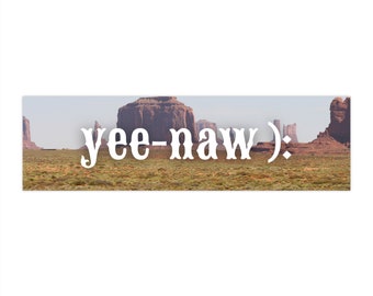 Op de afbeelding: Een panoramisch uitzicht op Monument Valley met rode rotsformaties in de verte. De tekst "yee-naw :)" is over de afbeelding gelegd.