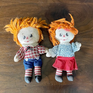 Muñecas Raggedy Ann y Andy de 15 cm, de Knickerbocker Toy Corp. HallmarkCard Inc., década de 1980, en rojo, blanco y azul, de poliéster y acrílico, lavables y aptas para secadora.