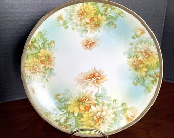 1905-1920 Prusia, Royal Rudolstadt, plato de porcelana pintado a mano, aguamarina sobre fondo blanco con aerógrafo, flores amarillas, naranjas y verdes. Excelente estado de conservación.