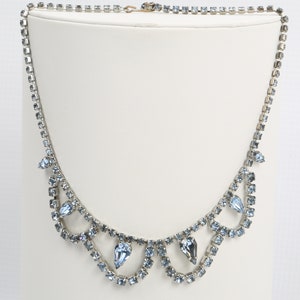 Blauwe kristallen choker gerhodineerd, midden cent. Hollywood Regency, geen slijtage, geen schade, alle stenen zijn veilig. Haak is vervangen.