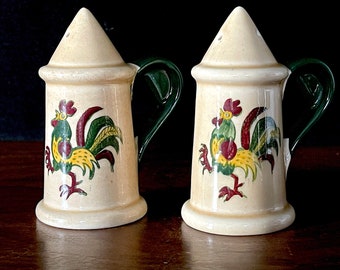 May include: A pair of ceramic salt and pepper shakers with green handles and rooster designs. The roosters are yellow, green, and red.