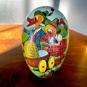 Portacaramelle a forma di uovo in cartapesta, prodotto dalla Germania Ovest negli anni '40, solitamente usato a Pasqua. Famiglia di anatre a passeggio. Ottime condizioni vintage.