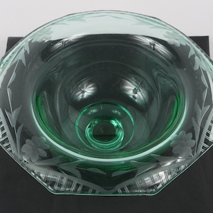 May include: A green glass bowl with an etched floral design. The bowl has a scalloped edge and a clear base.