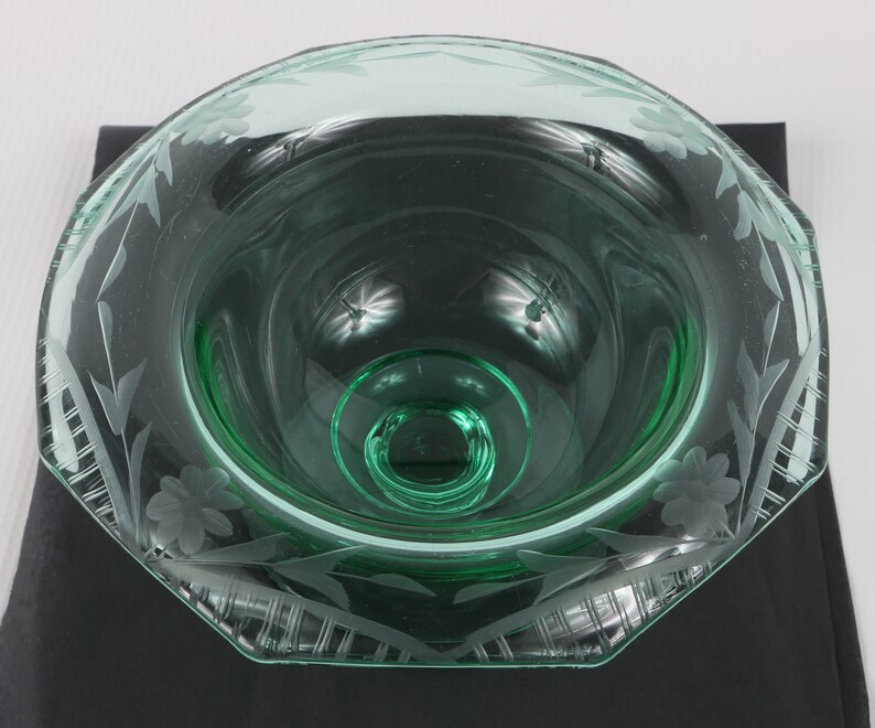 May include: A green glass bowl with an etched floral design. The bowl has a scalloped edge and a clear base.