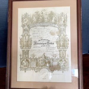 Certificado de Bautismo de 1881-94. Iglesia Luterana Sión de Nebraska. Sello en relieve. Bajo vidrio en marco de madera. Excelente condición de antigüedad. Documento histórico.