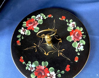 Bandeja redonda en relieve de metal negro o toleware pintada a mano de los años 50-60, con vibrantes flores y detalles dorados en el poste central y asa de anillo. Sin daños.