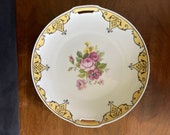 1912-1945 R S Germany Porcelain CakePlate, Reinhold Schlegelmilch Yellow, Pinks Floral Center and Yellow, Black Scroll Border. 9-3 4 quot Diam.