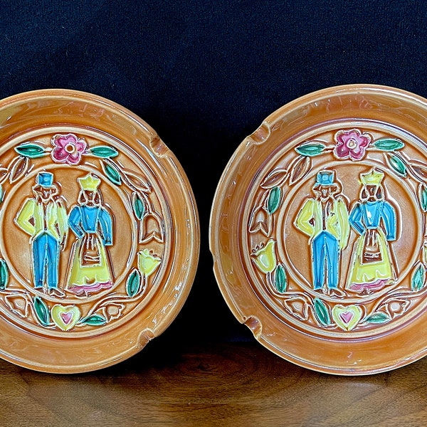 1960's Brinn's, Two PA Dutch Themed Ashtrays, Tan with Pink, Blue, Yellow, and Green Glazed 3D Molded Couple w Floral, 5" Wide, Some Chips