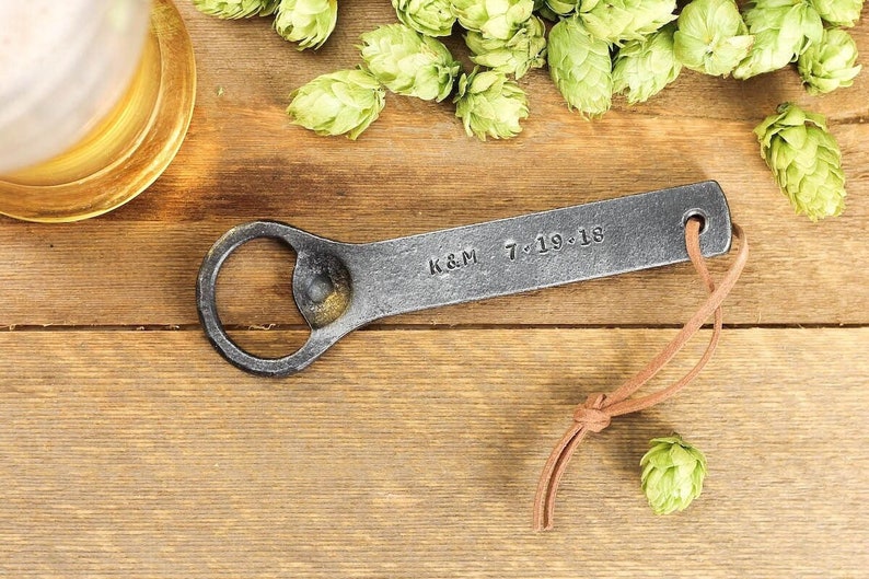 Personalized hand forged Iron bottle opener on a rustic background.