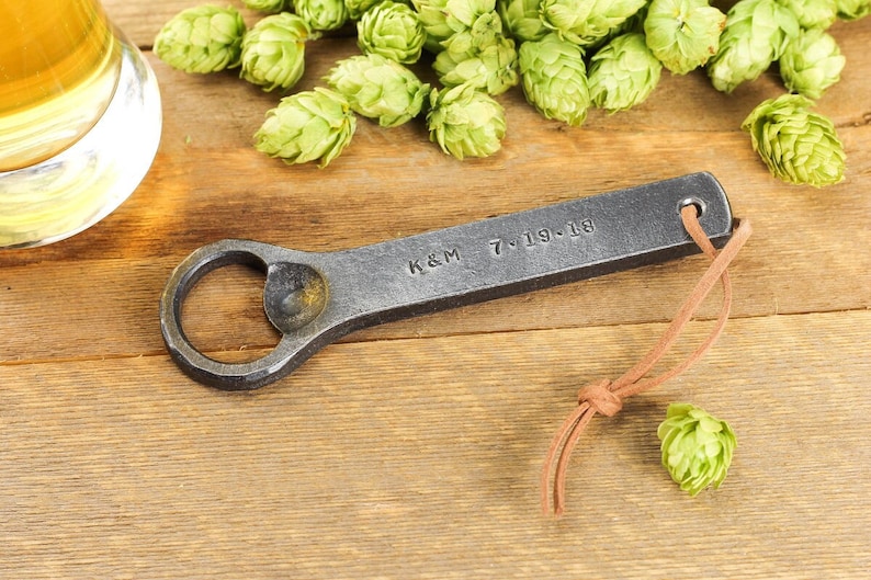 Customized hand forged Iron bottle opener on a rustic background.