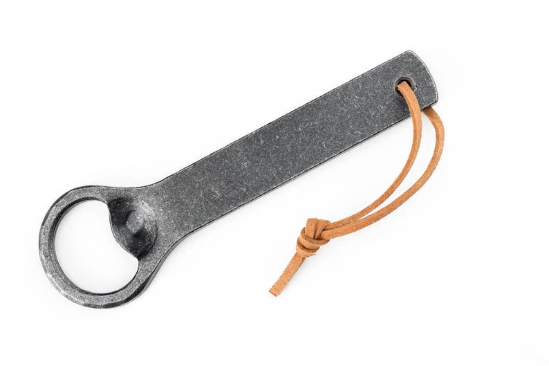 A gray hand forged iron bottle opener on a white background.