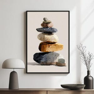 Può includere: Stampa artistica incorniciata con una pila di pietre colorate. Le pietre, in tonalità di grigio, marrone e beige, sono disposte in una torre equilibrata. L'opera d'arte è esposta su uno sfondo neutro, esaltando i toni naturali.