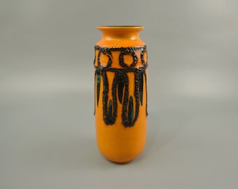 May include: Orange ceramic vase with black and green geometric designs. The vase has a textured surface.