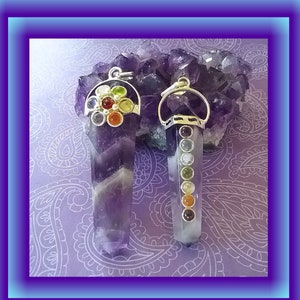 May include: Two amethyst crystal pendants with silver settings. One pendant has a cluster of seven colorful gemstones, while the other has a row of seven gemstones in different colors.