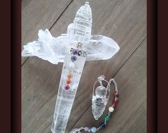 Può includere: Una bacchetta di cristallo di quarzo trasparente con sette pietre dei chakra e un pendolo di cristallo di quarzo trasparente con una catena di pietre dei chakra.