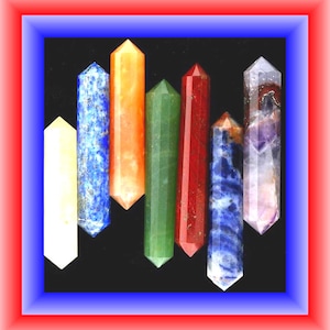 May include: A collection of seven double-terminated crystal wands arranged vertically. The stones feature various colors and textures, including opaque white, speckled blue, translucent orange, solid green, deep red, mottled blue, and purple-tinted quartz.