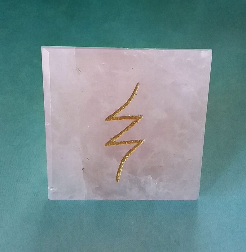 May include: A pink rose quartz pyramid with a gold "life force" symbol etched on the front.