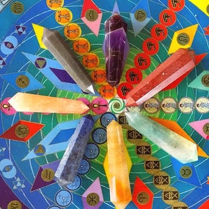 May include: Seven double-terminated crystal points in purple, red, orange, yellow, green, blue, and gray arranged in a circular pattern on a colorful circular board featuring various symbols, zodiac signs, and geometric shapes.