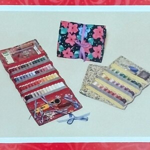 May include: A book cover titled "The Traveling Quilter" by Patricia B. Campbell, featuring a red background with a floral pattern. The image includes sewing kits and fabric bundles with floral patterns and ribbons. The Heart & Home Pattern Co. logo is at the bottom.