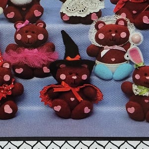 May include: A pattern sheet titled "Lov'n Stuff" featuring a collection of brown teddy bears dressed in various costumes. The bears are approximately 5 inches tall and include a Santa bear, a witch bear, and a cowboy bear. The text reads "Bunches of Bears."