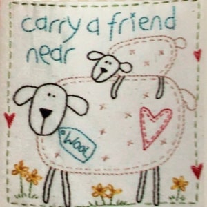 May include: A framed fabric art piece with the text "CARRY A FRIEND" and "Sweet Sentiments". The artwork features a sheep with a smaller sheep on its back, stitched in white thread. Includes a tag that says "wool".