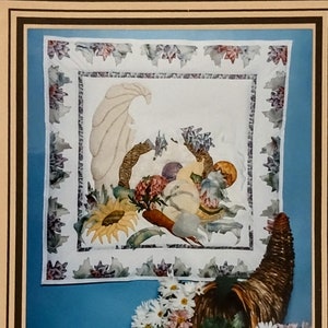 May include: A framed artwork titled "Cornucopia" by Connie D. Roys. The image features a cornucopia overflowing with fruits and vegetables, with a detailed embroidered design. The dimensions are 25 1/2 inches long by 26 1/2 inches wide.