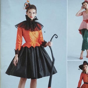 May include: Simplicity Costumes pattern featuring three Halloween costume designs. The main image showcases a witch costume with an orange and black dress, a black broom, and a black collar. The pattern includes sizes 6-14.