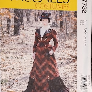 May include: McCall's Costumes sewing pattern M7732 featuring a vintage-style dress. The pattern includes a long, red and black plaid skirt and a matching jacket with gold buttons. The model is wearing a hat with feathers. The pattern is size AAX (4-6-8-10).